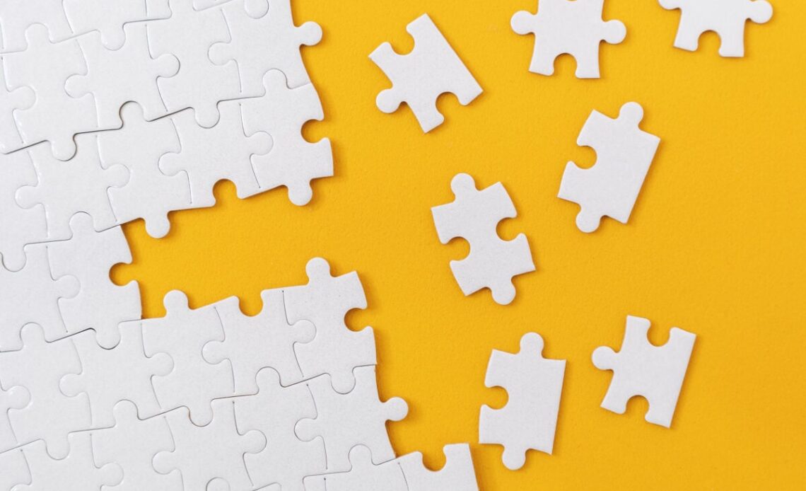 Partially complete jigsaw puzzle with scattered missing pieces