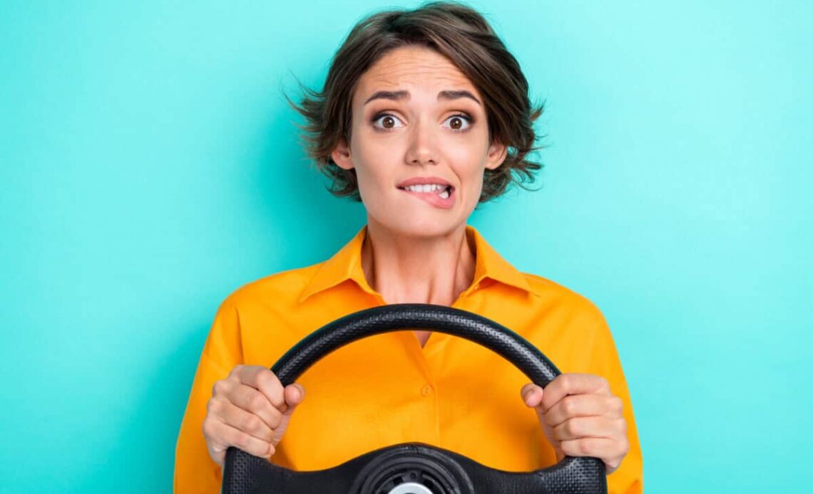 woman holding steering wheel is nervous about the future