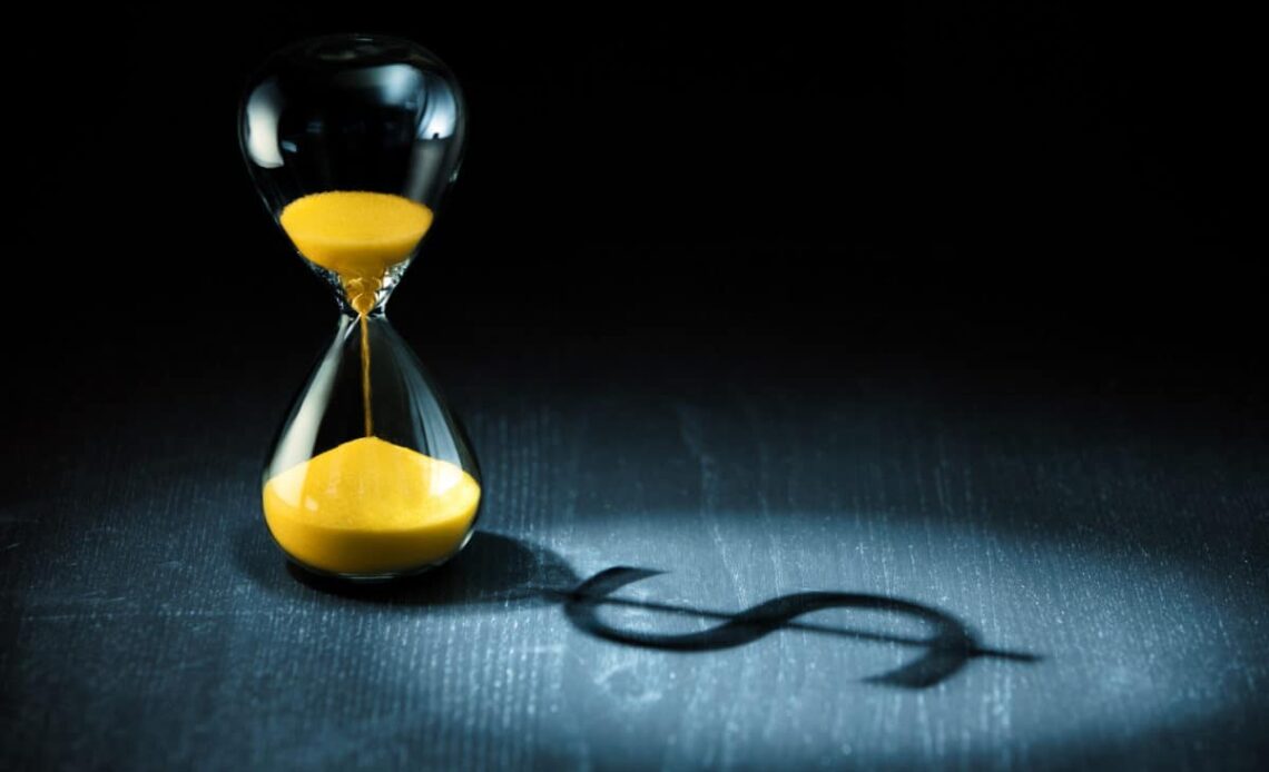 Hourglass projecting a dollar sign as shadow